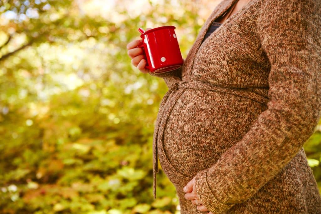 pregnant woman holding a red cup