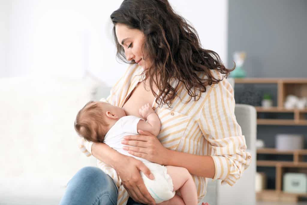 woman breastfeeding child in a shirt